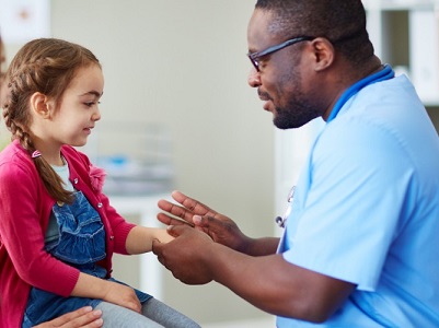 Gentleman with short brown hair with a blue shirt on speaking with a girl child who has long brown hair in a braid with a red sweater and blue overalls.